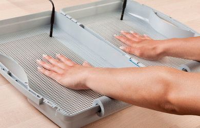 Una persona está tocando una bandeja con sus manos.