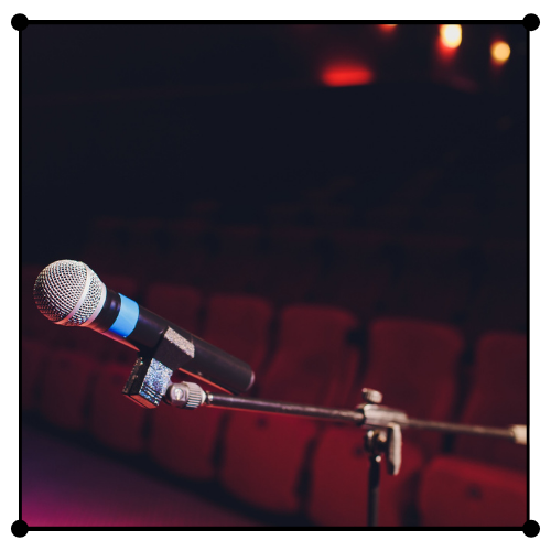 Un micrófono está sobre un soporte en un auditorio.