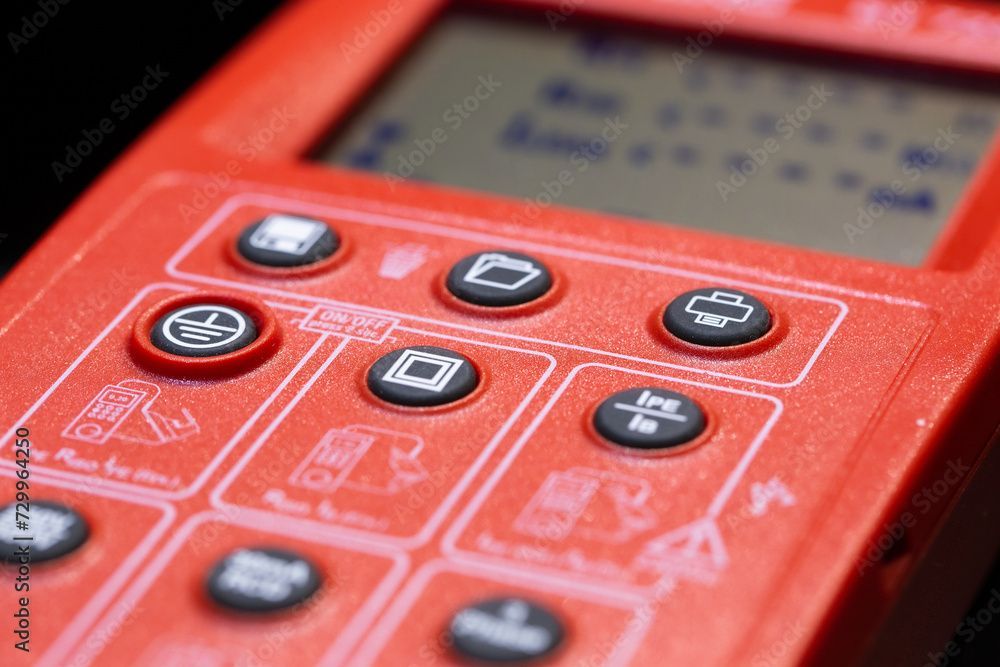 Auf einem Tisch steht ein digitales Multimeter mit zwei daran angeschlossenen Sonden.