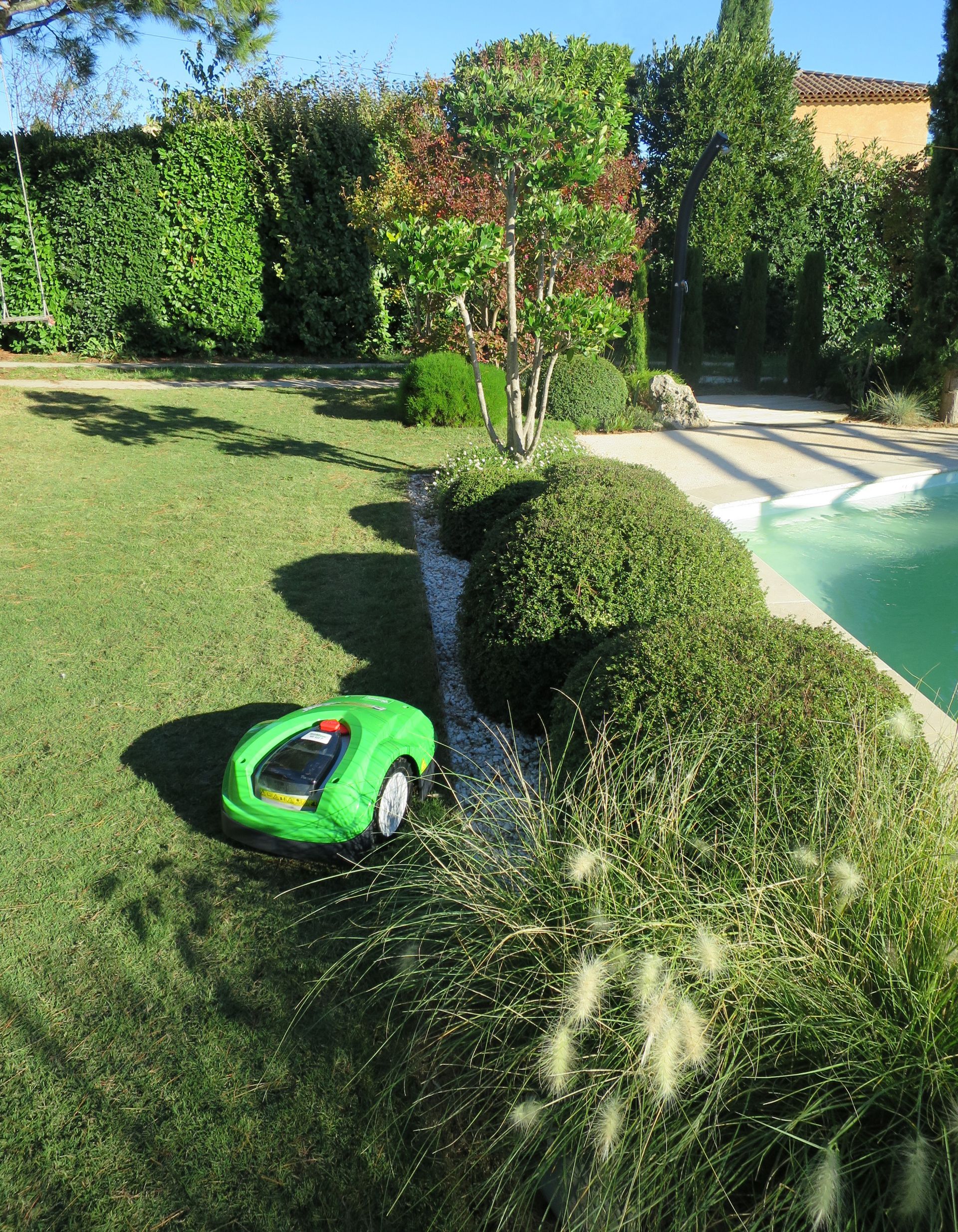 Un robot tondeuse qui passe sur les bordures du jardin