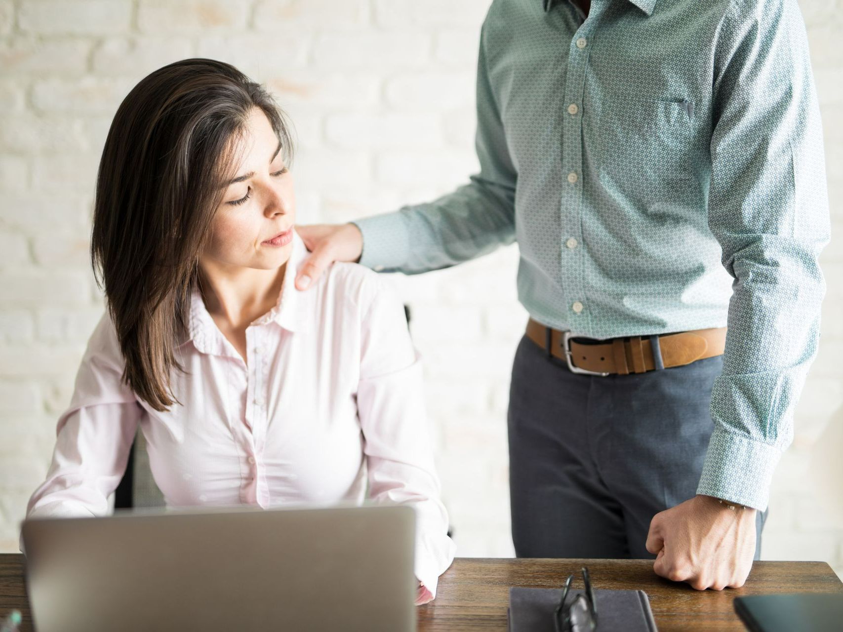 Femme qui regarde une main sur son épaule