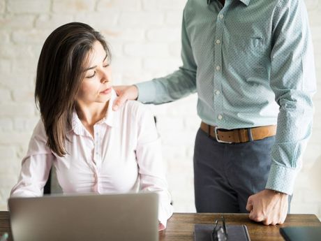 Femme qui regarde une main sur son épaule