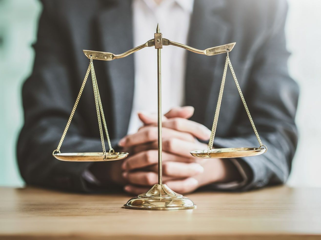 Parsonnage en costume derrière une balance illustrant la justice
