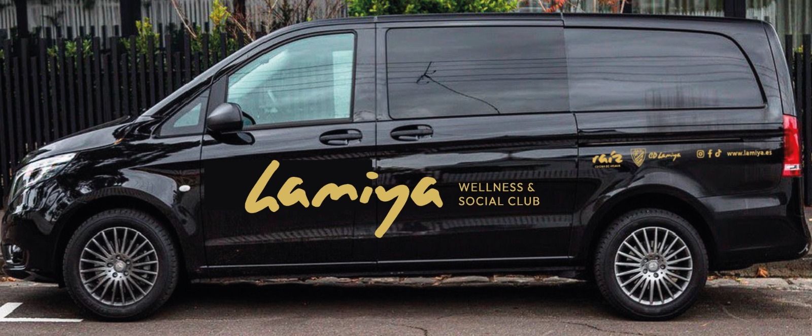 Una camioneta negra con la palabra Lamiya en el costado está estacionada en un estacionamiento.