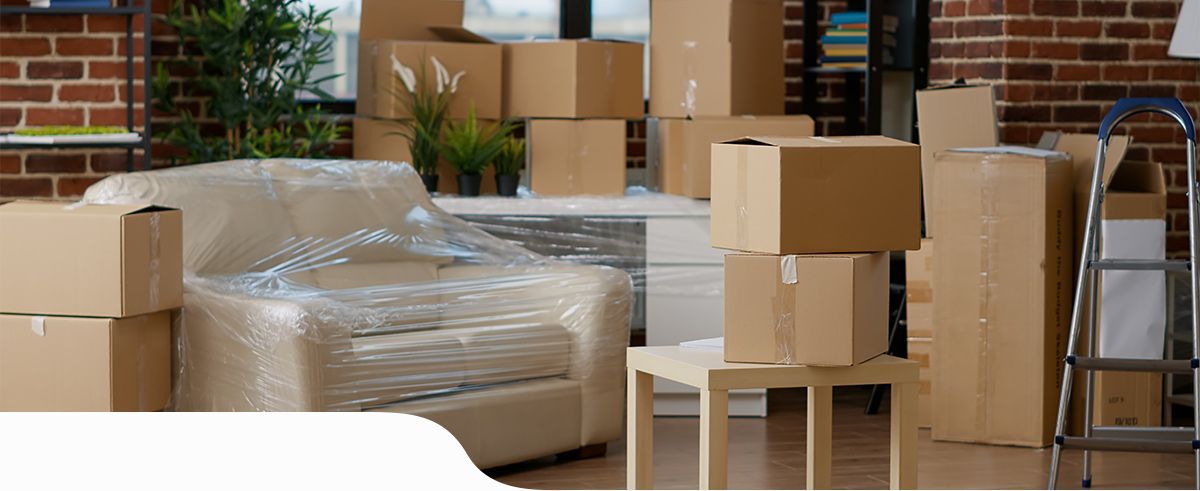 Cartons de déménagement et fauteuil entouré de cellophane