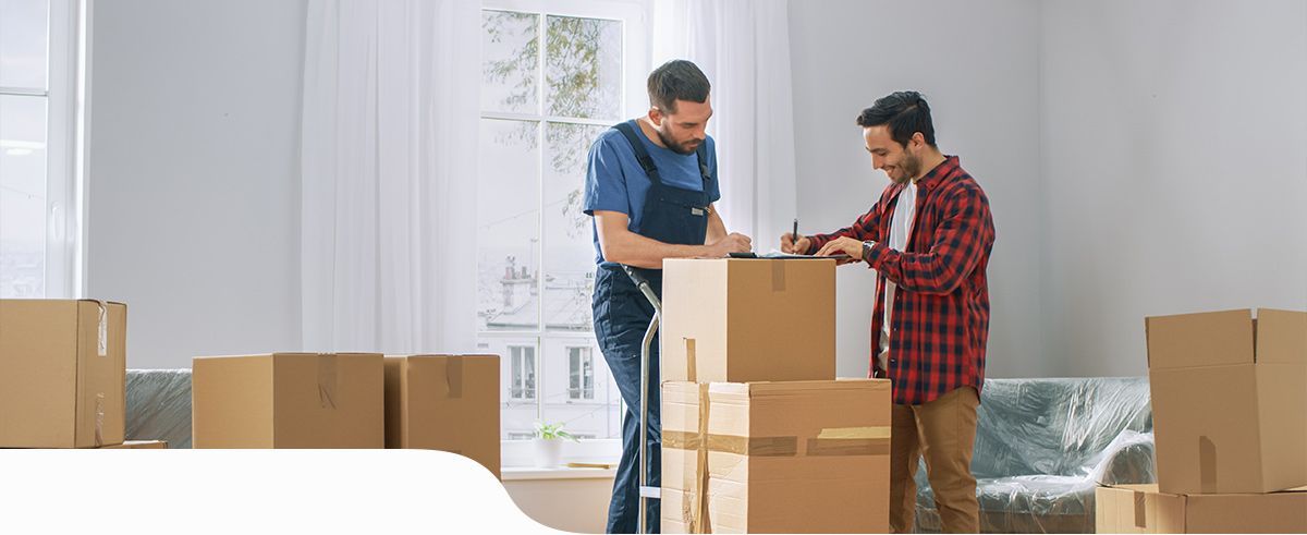 Signature d'un document posé sur des cartons de déménagement