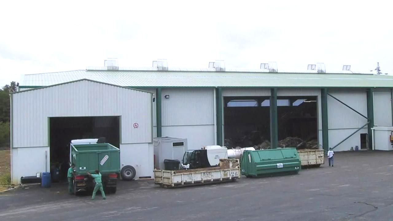 Vue de l'extérieur des hangars de tri des déchets sur le site de la déchetterie.