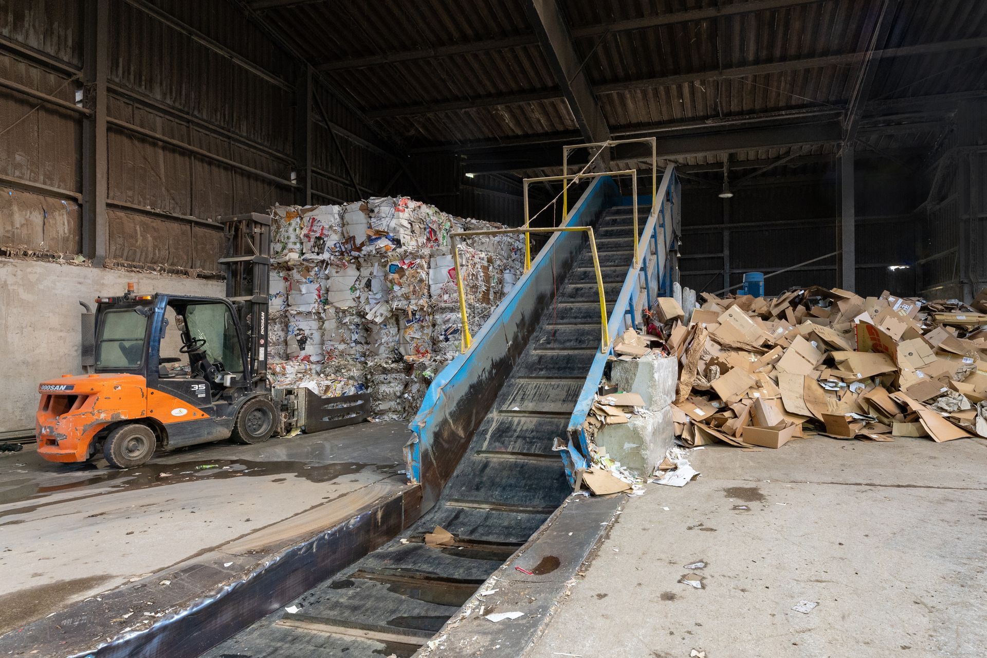 Hangar avec une machine de compactage des déchets de type carton.
