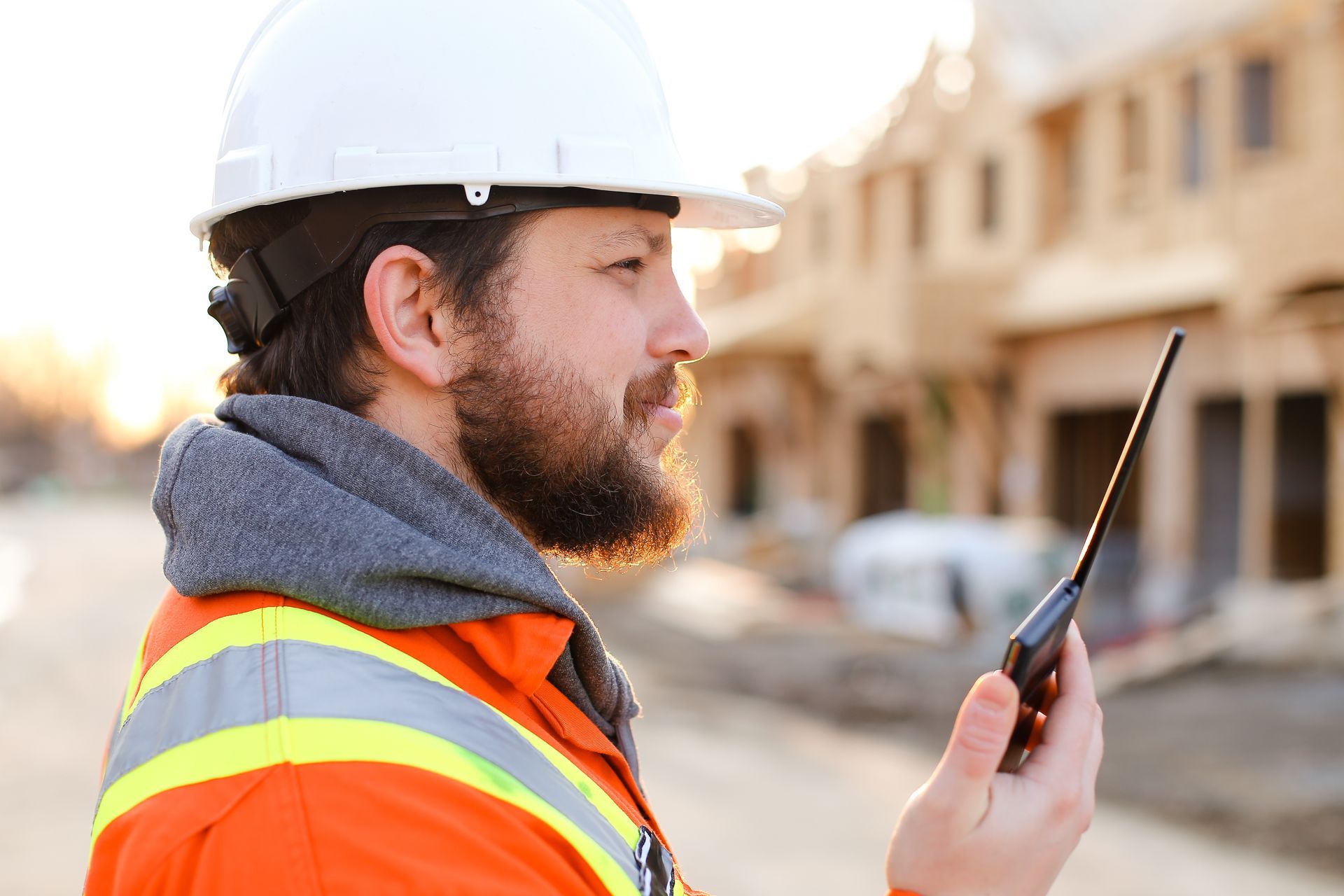 Un professionnel du bâtiment avec un talkie-walkie sur un site de construction.