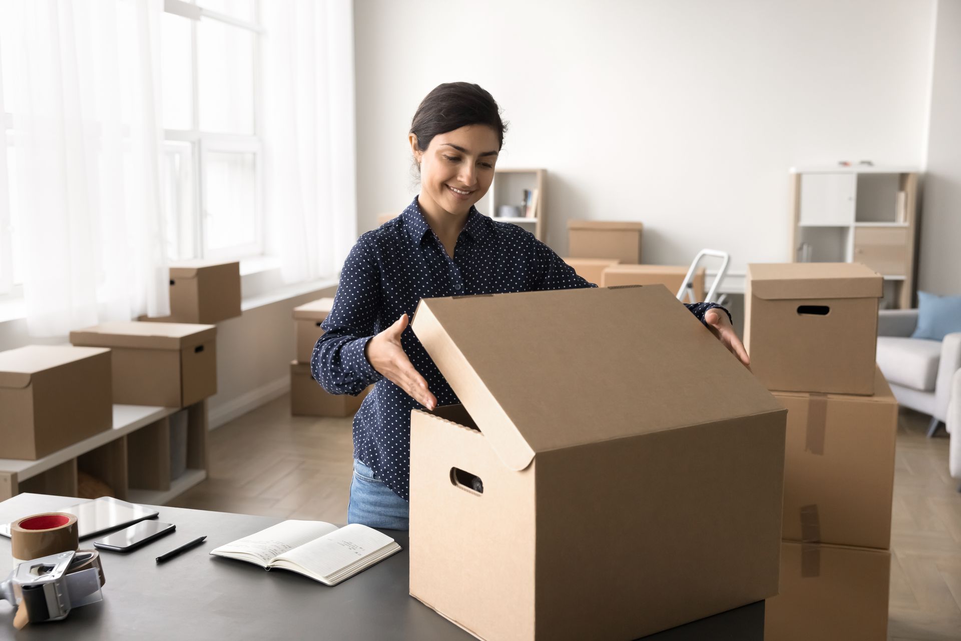Une femme dans un bureau faisant des cartons de déménagement.
