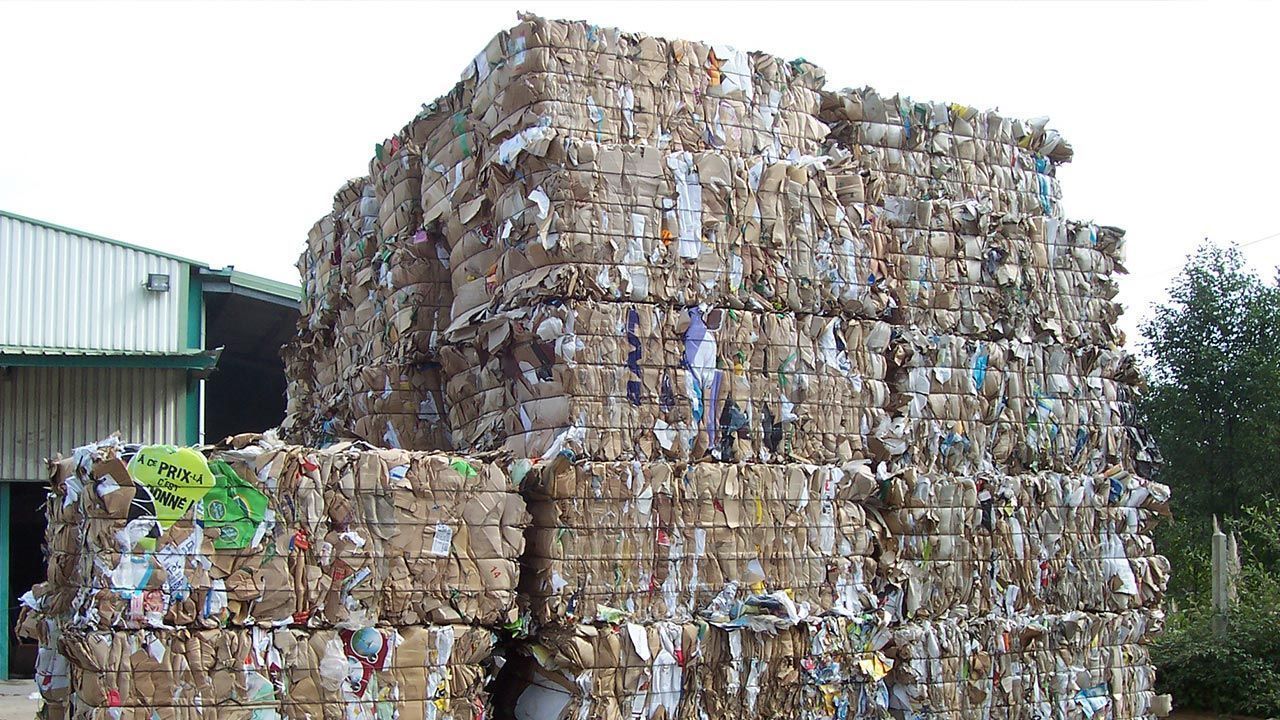 Un très haute pile de cartons compactés.