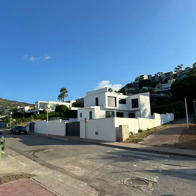 Una gran casa blanca se encuentra en la cima de una colina.