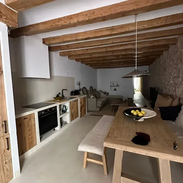 Una cocina con una mesa y un banco en ella.