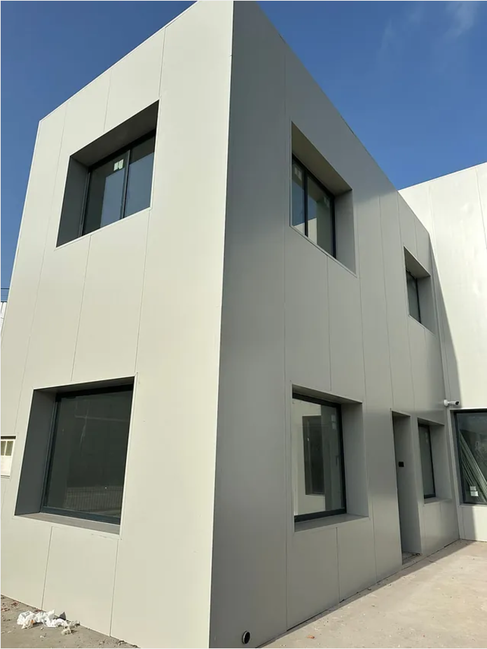 Un gran edificio blanco con muchas ventanas y una puerta de garaje.