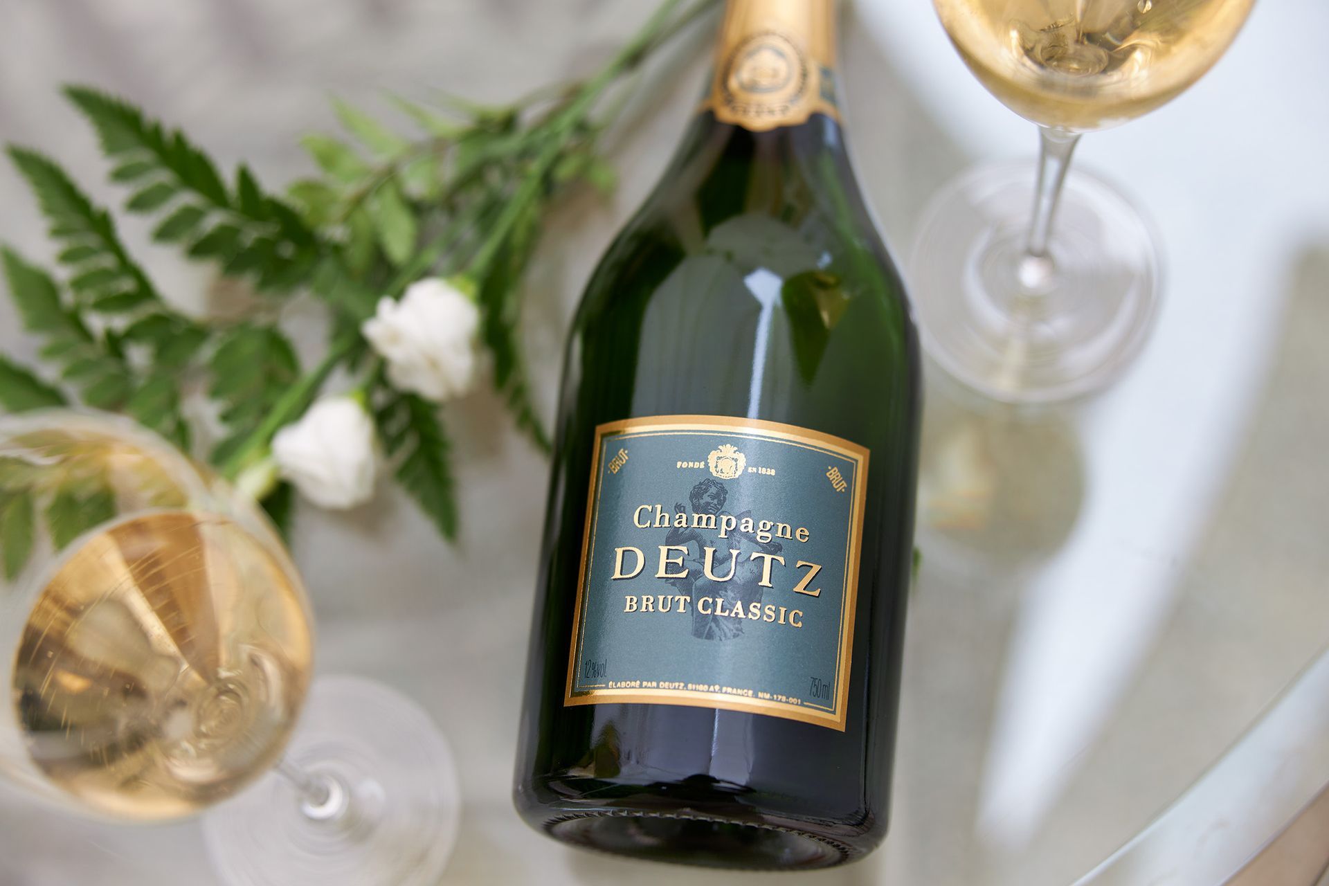 Bouteille de champagne Deutz entourée de deux verres