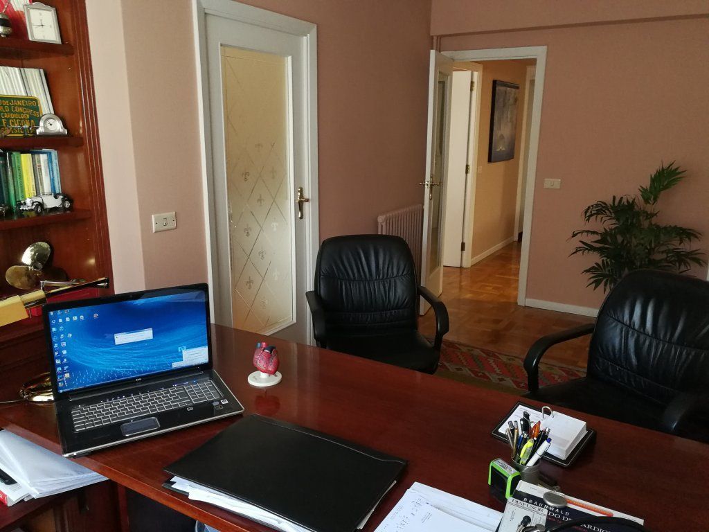 Una computadora portátil se encuentra sobre un escritorio en una oficina.