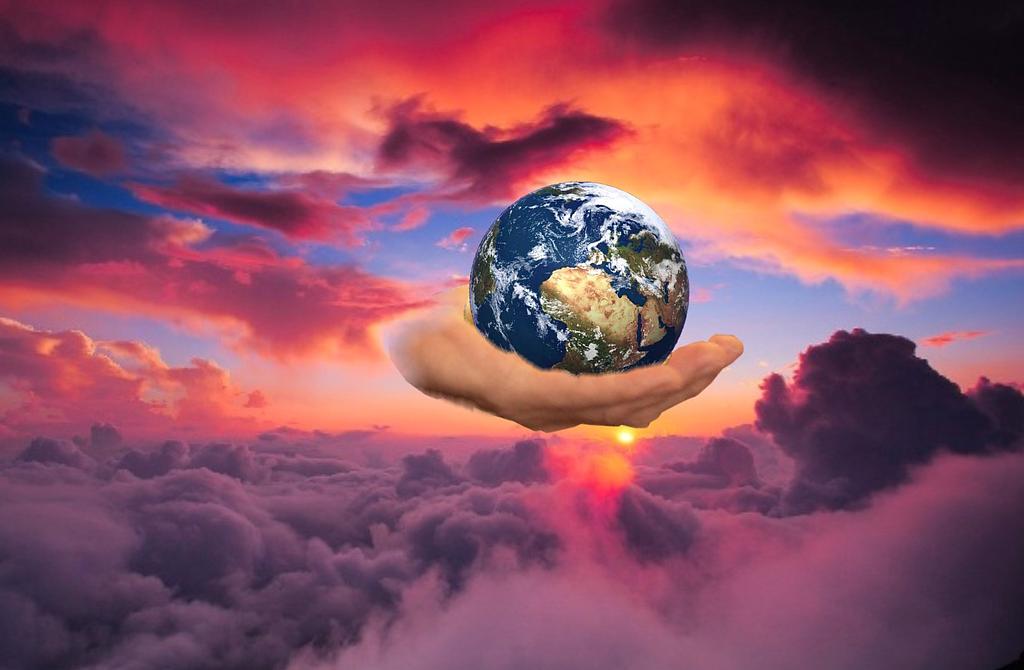 Montage de la Terre dans une main, sur un fond de nuages