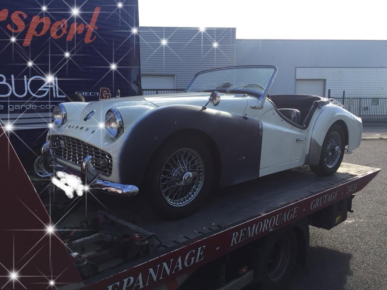 Une ancienne voiture se faisant dépanner.