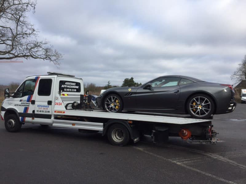 Ue voiture de luxe se faisant dépanner.