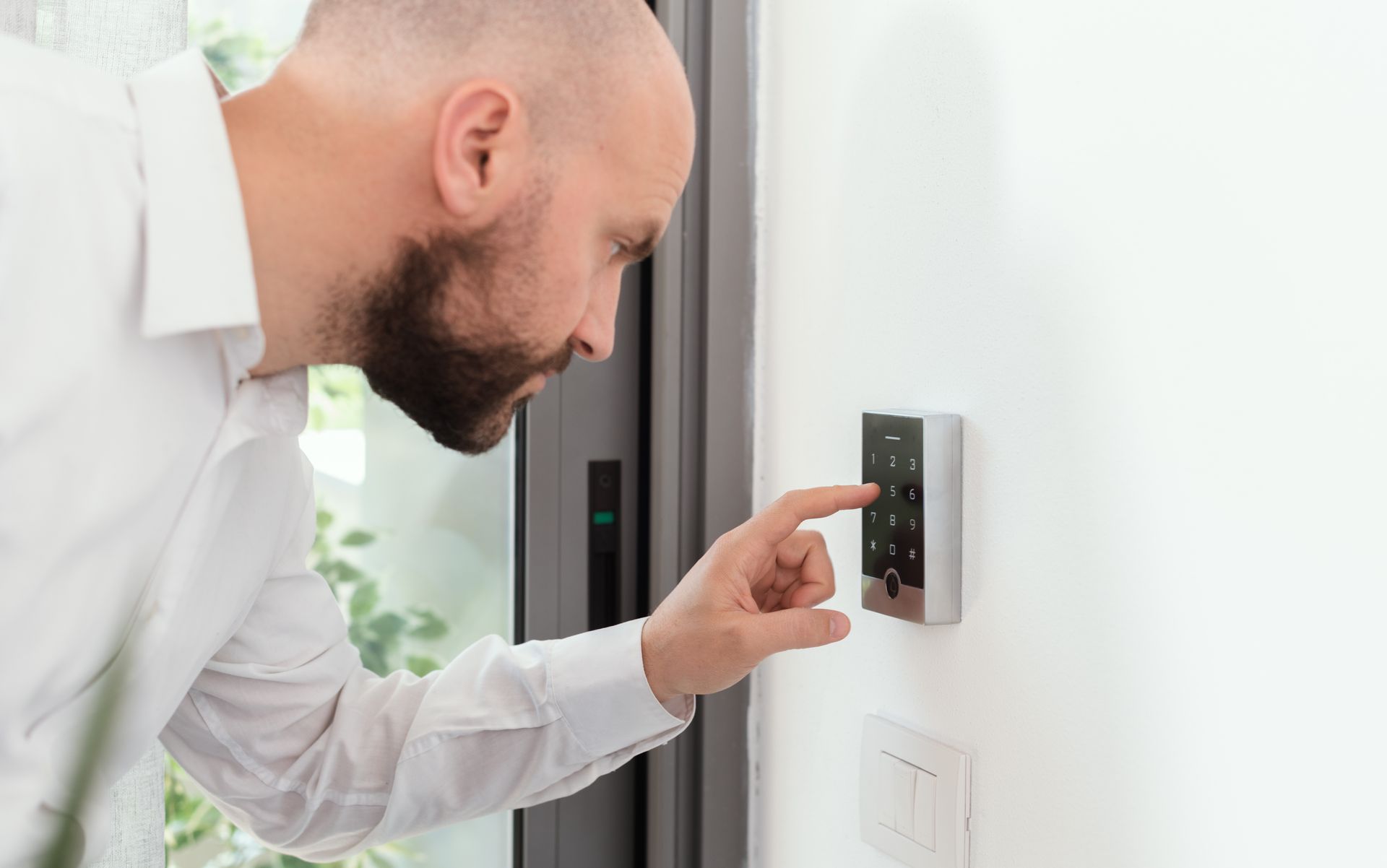 Un homme compose un code sur un clavier de sécurité.
