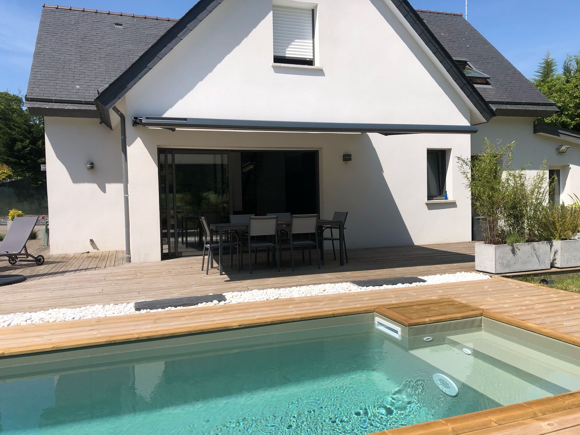 Une maison avec un store et une piscine