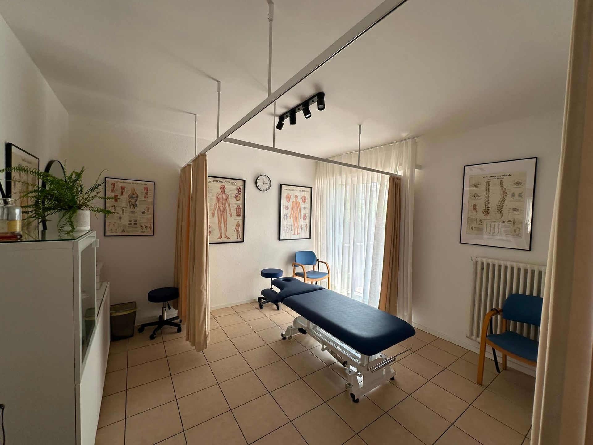 Palestra domestica con attrezzi per esercizi, specchi e una palla da fitness blu su un pavimento in legno.