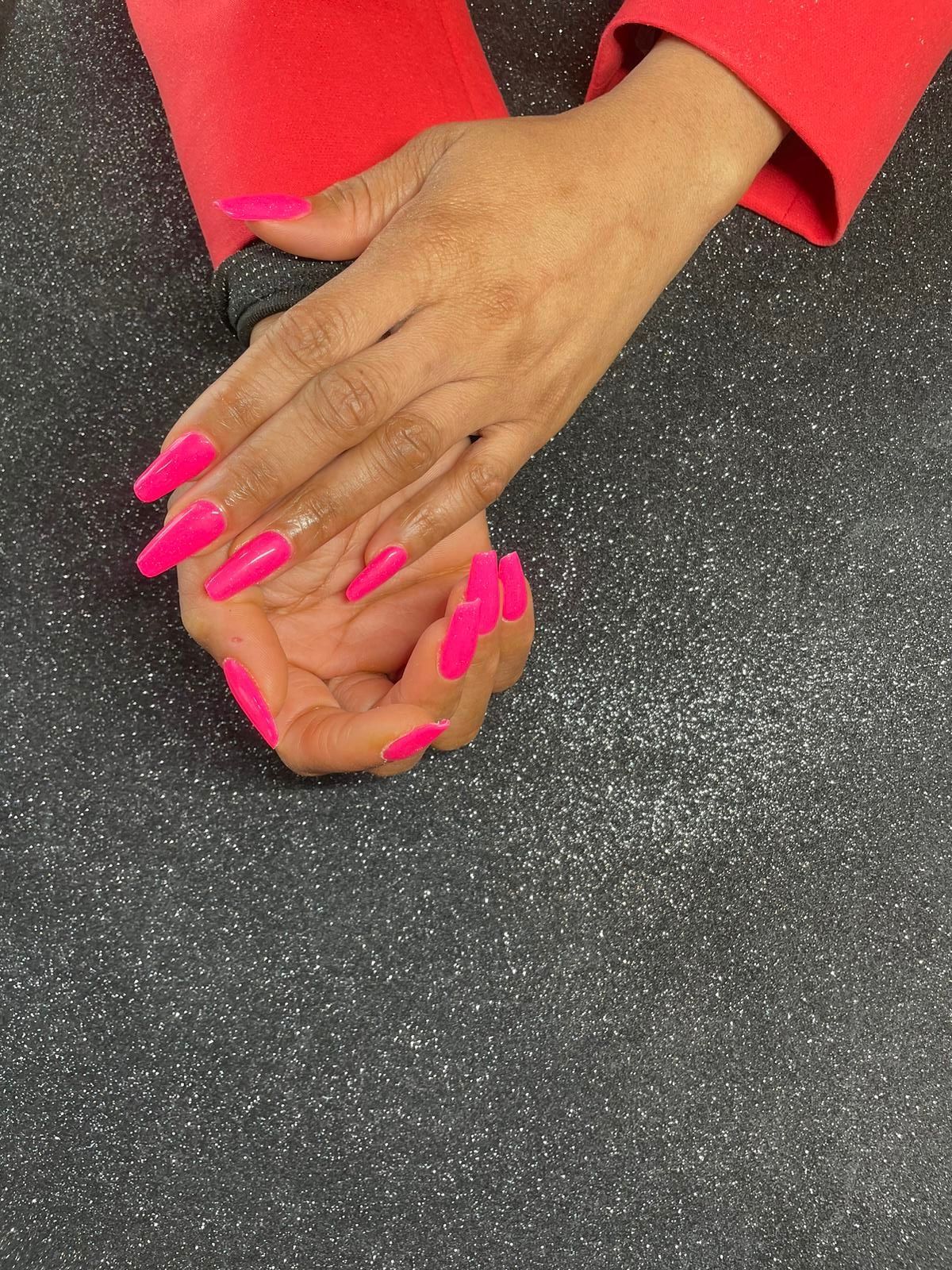 Les mains féminines avec le vernis rose.