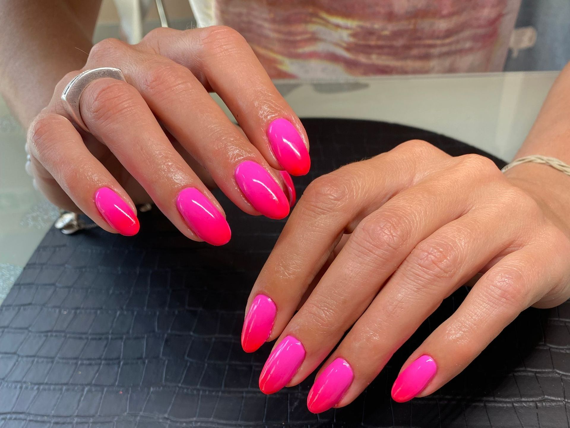 Gros plan sur les mains d'une femme avec la manucure rose.