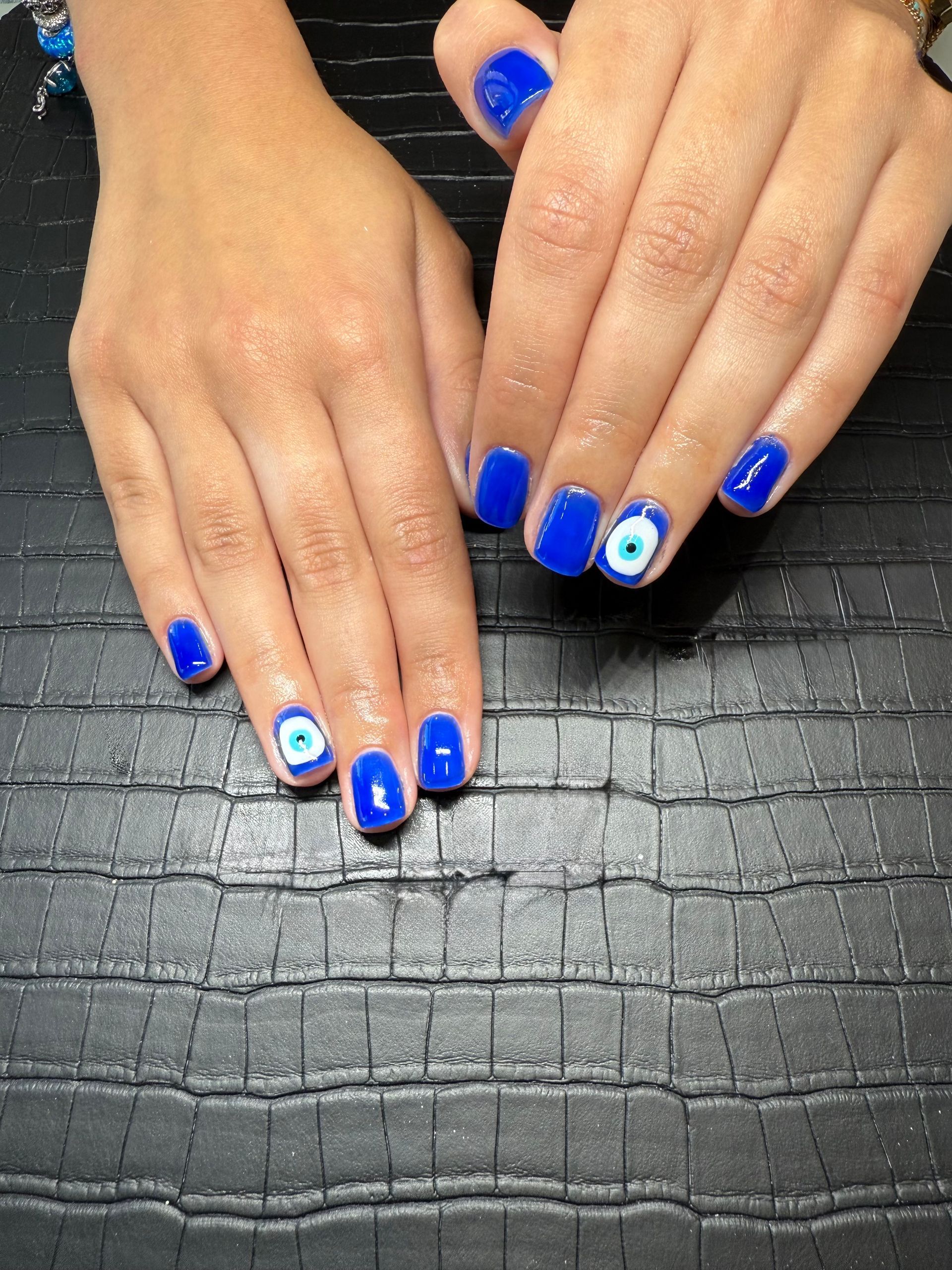 Les mains féminines avec la manucure bleue.