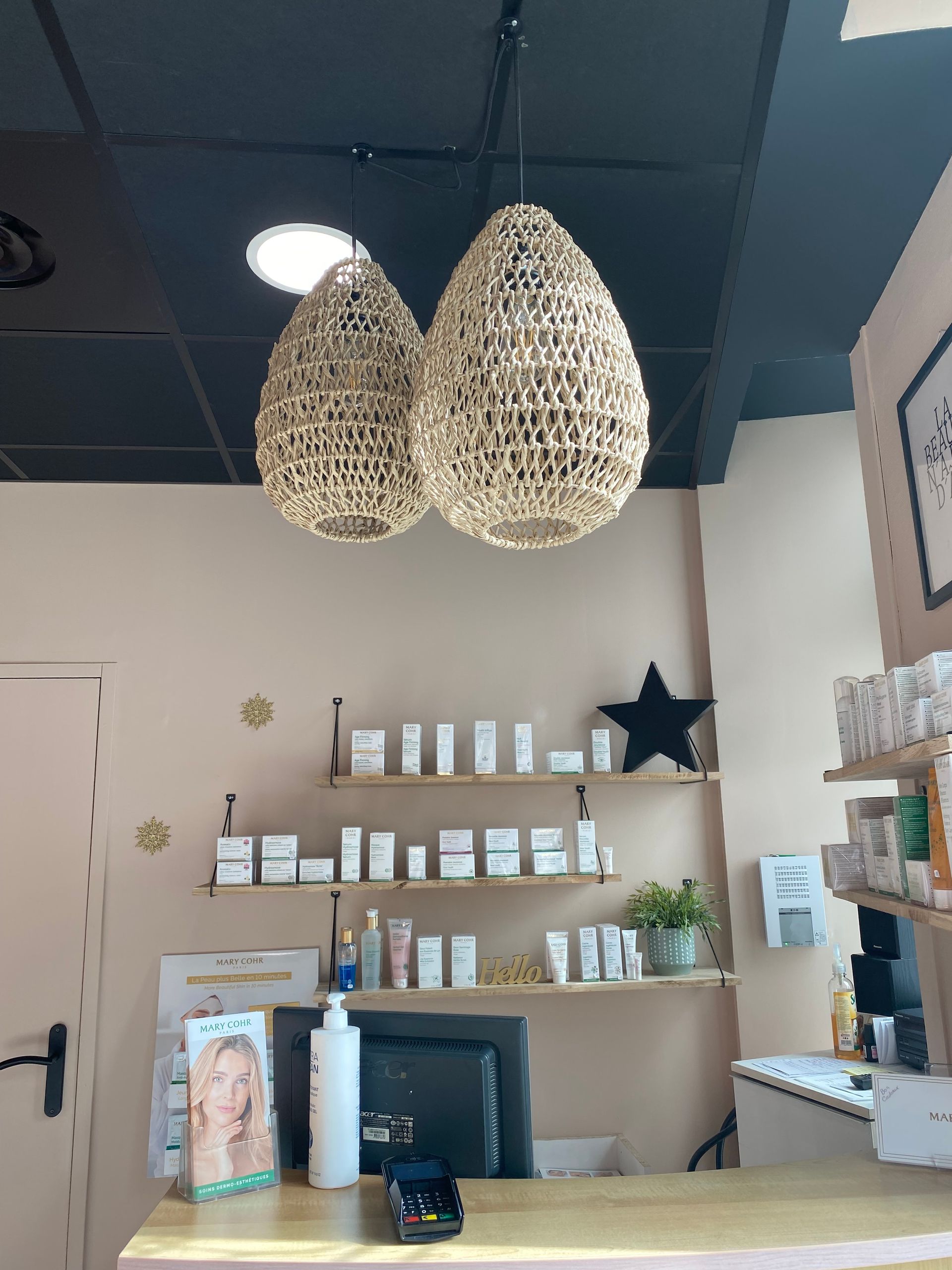 Espace d'accueil de l'institut avec le comptoir et les produits cosmétiques en arrière-plan.