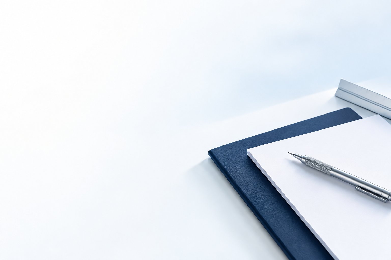 Cuaderno y bolígrafo sobre una mesa blanca y azul para planificar un proyecto