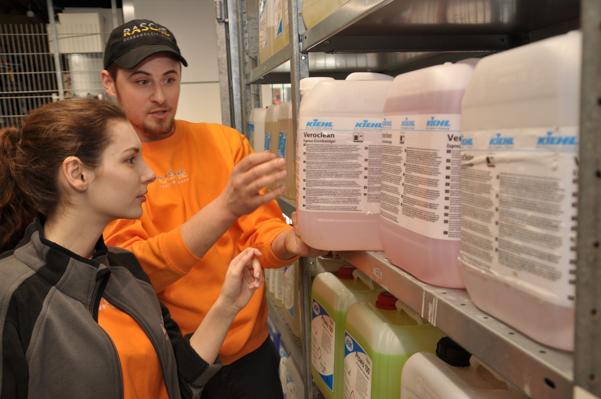 Ein Mann und eine Frau schauen sich Kanister mit Reinigungsmitteln auf einem Regal an.