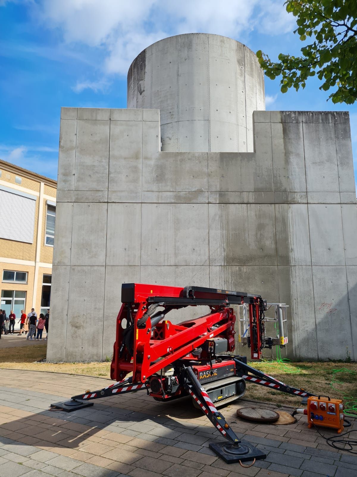 Ein roter Kran steht vor einem Betongebäude
