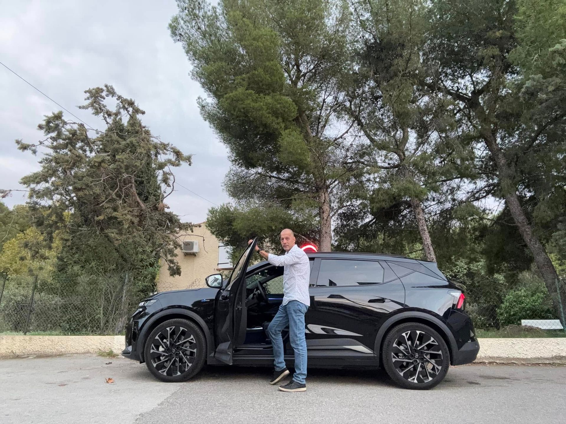 Un homme en chemise et jeans monte en voiture