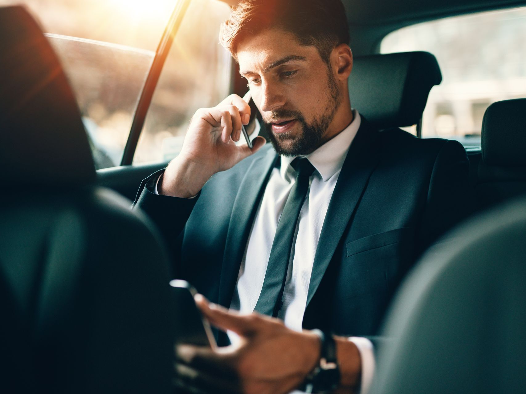 Homme d'affaires au téléphone dans une voiture