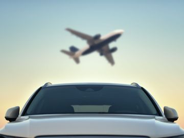 Voiture avec un avion en arrière-plan