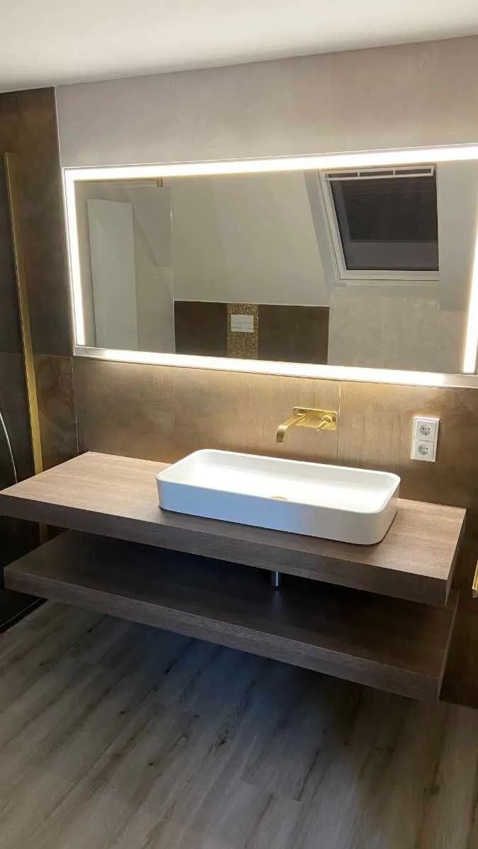 Komplettbad mit braun-goldener Einrichtung und goldenen Armaturen