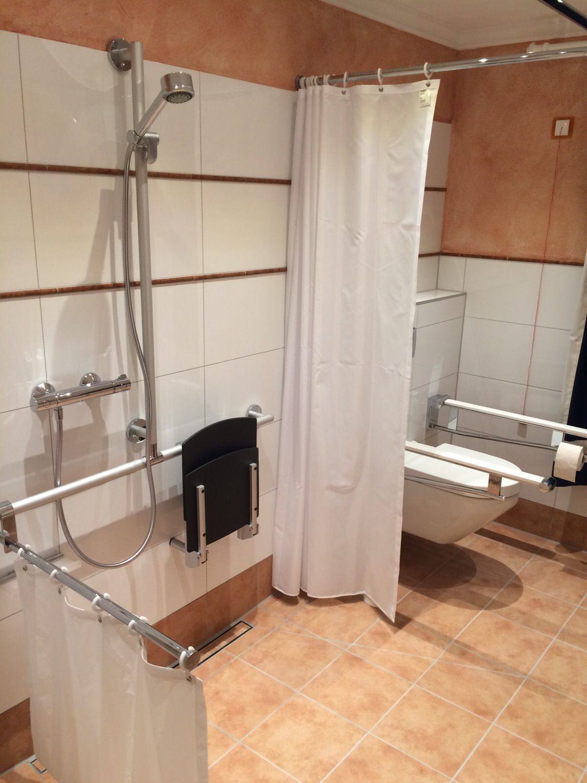 Barrierefreies Badezimmer mit Hockern und Halterungen