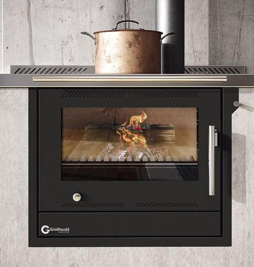 Cuisinière à bois moderne encastrée dans un mur.