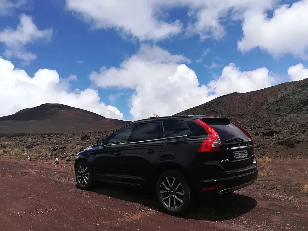 Taxi arrêté à côté des dunes volcaniques