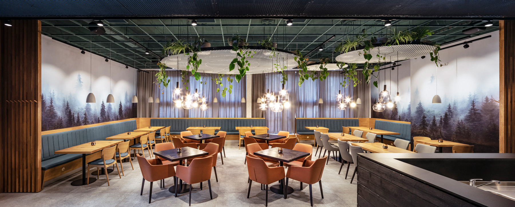 Restaurantinterieur mit Tischen, Stühlen, Sitznischen und Hängelampen. Mit Waldmotiv, Pflanzen und Holzelementen.
