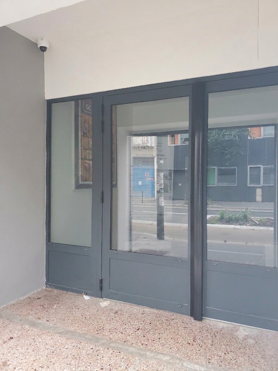 Entrée de magasin vide avec portes et fenêtres en verre gris sous un passage couvert