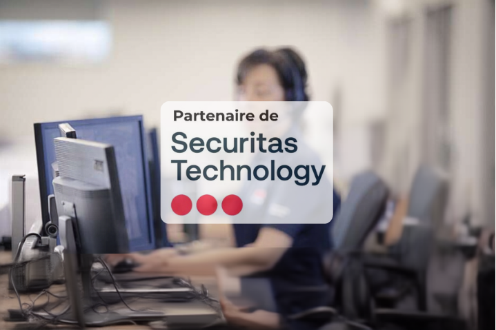 Bureau avec poste de travail informatique flou et panneau « Partenaire de Securitas Technology » superposé