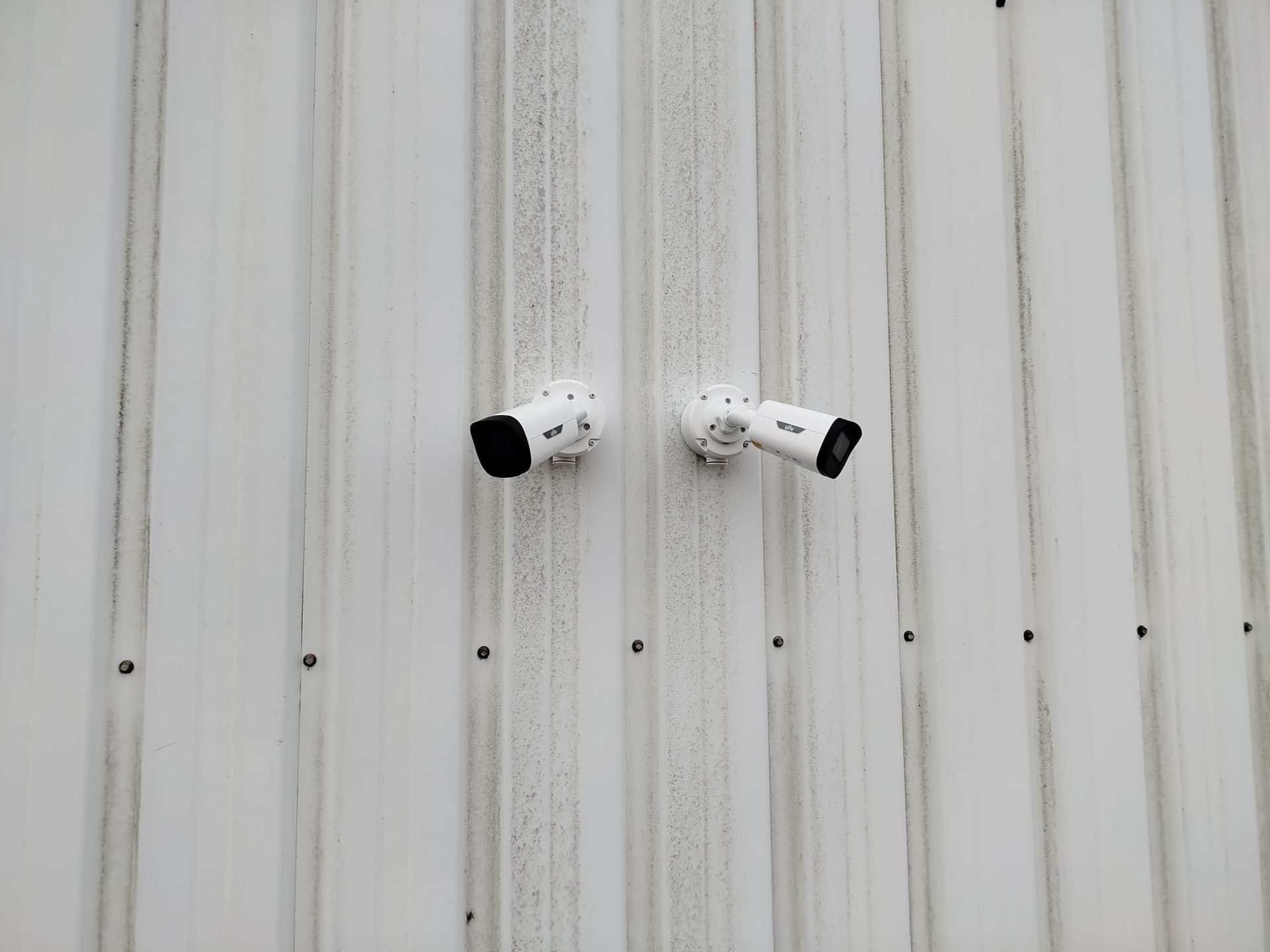 Technicien posant une caméra de vidéosurveillance sur un site professionnel