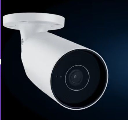 Caméra de sécurité blanche avec objectif noir, fixée au plafond sur fond sombre.
