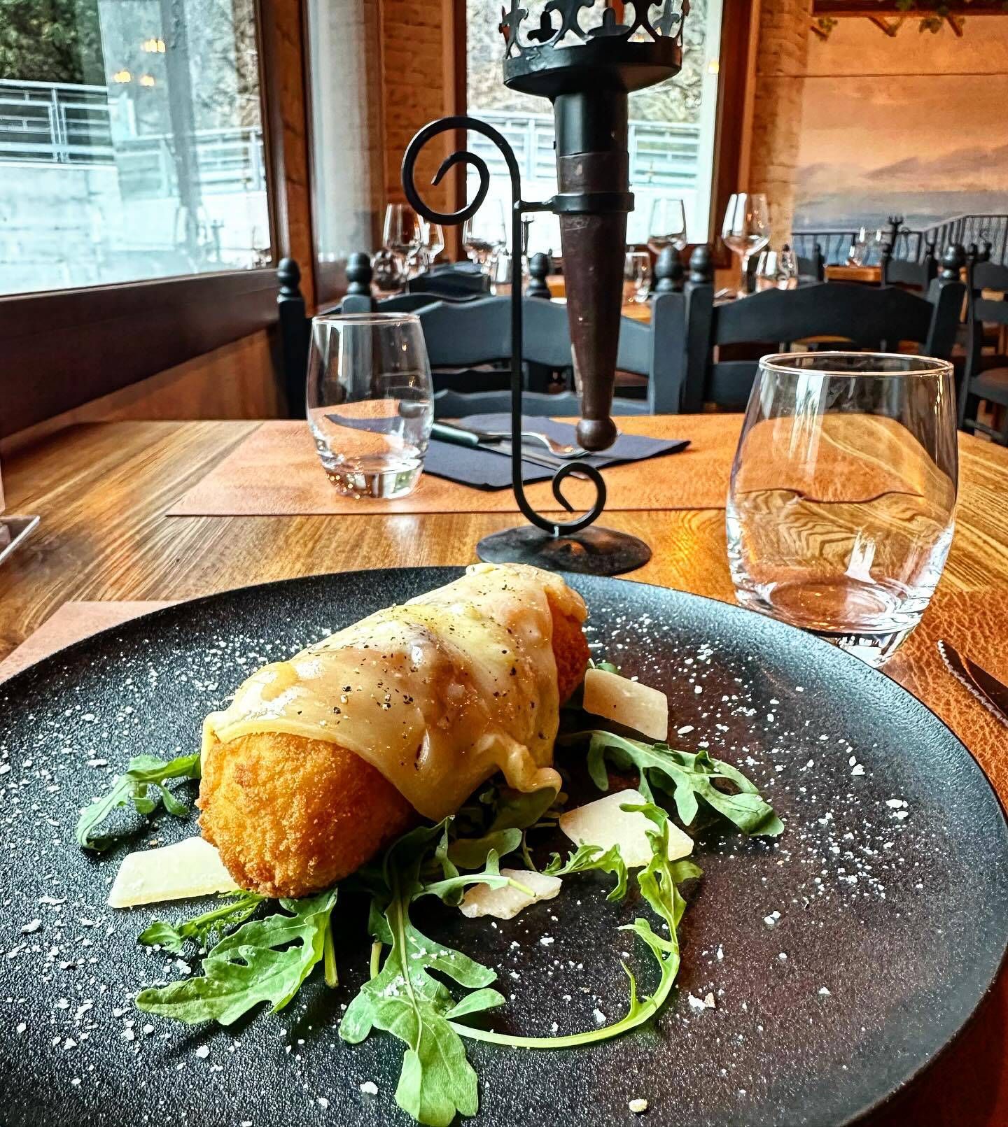 Une assiette de nourriture est posée sur une table en bois dans un restaurant.