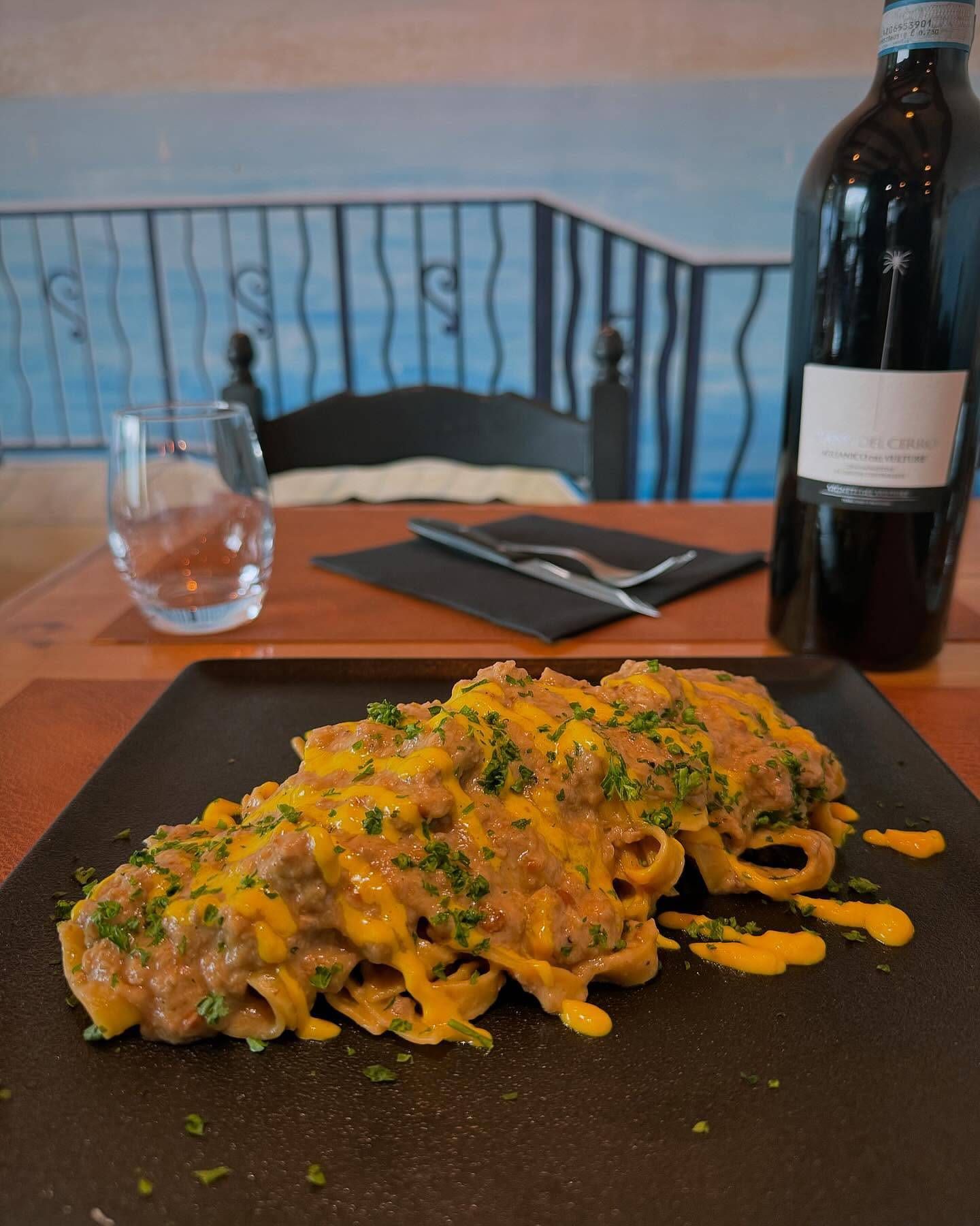 Une assiette de nourriture est sur une table à côté d'une bouteille de vin.