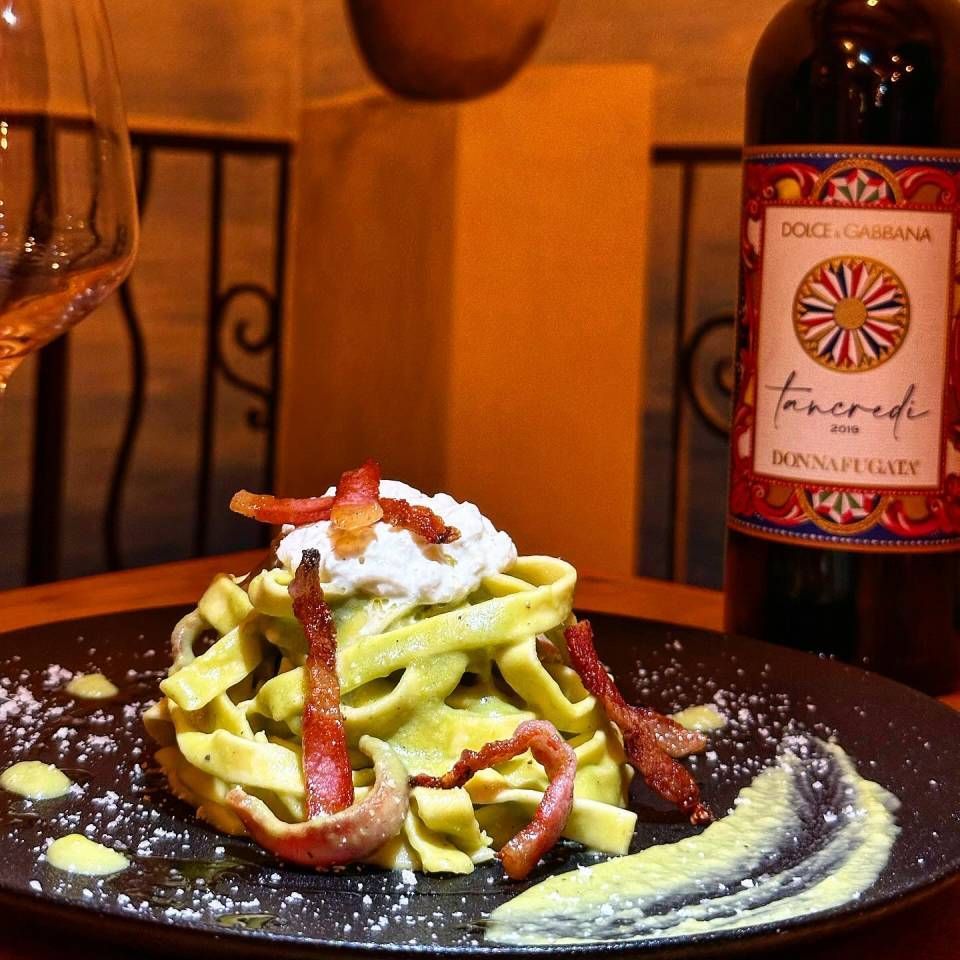 Une bouteille de vin Dolce & Gabbana à côté d'une assiette de nourriture