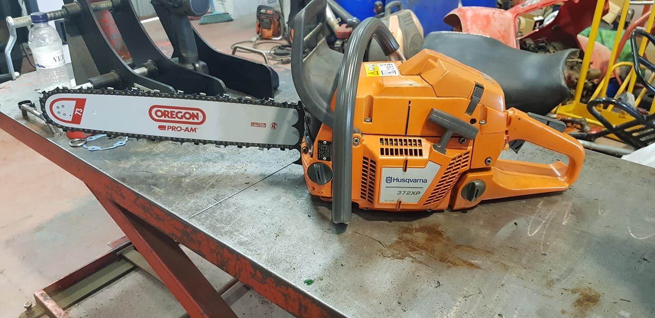 Una motosierra está colocada encima de una mesa de metal.