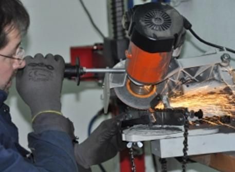 Un hombre está usando una motosierra para cortar un trozo de metal.